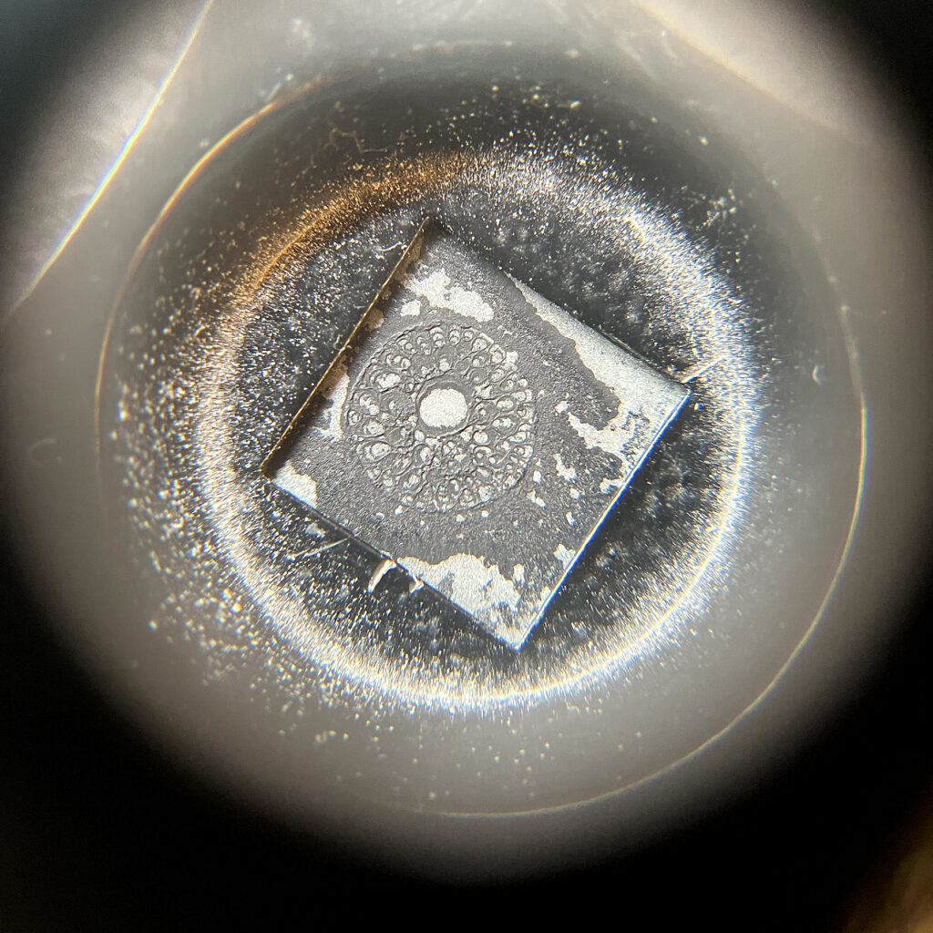 View through a thread counter (magnifying glass) of a zinc plate with toner wash