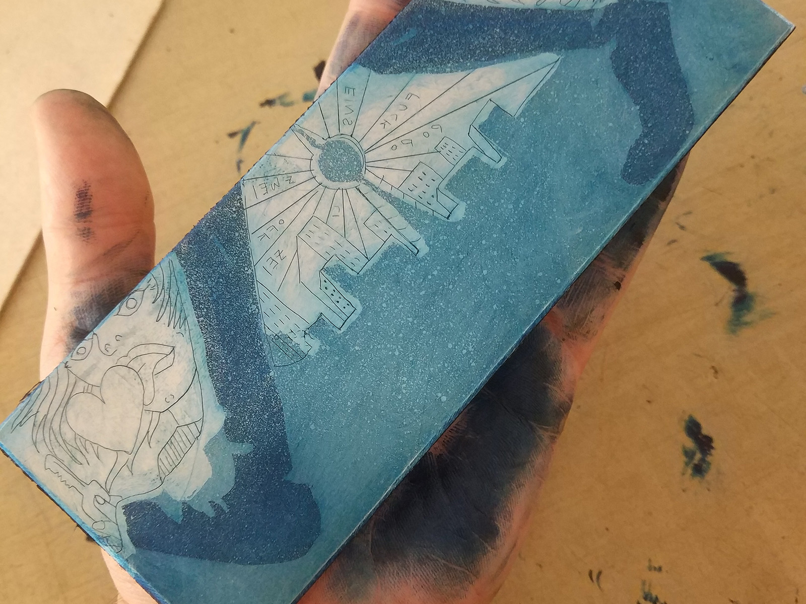 Eine Hand hält eine eingefärbte Zinkplatte, bereit für den Druck